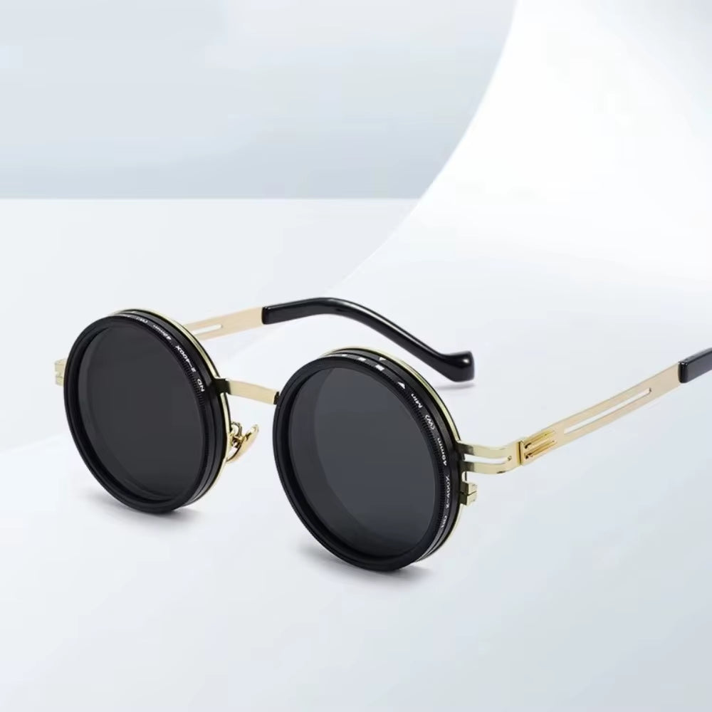 Round sunglasses with gold frame and black lenses on a light gray background